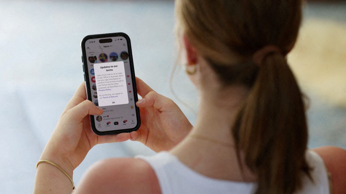 Έφηβη διαβάζει μήνυμα από το TikTok για τους όρους χρήσης