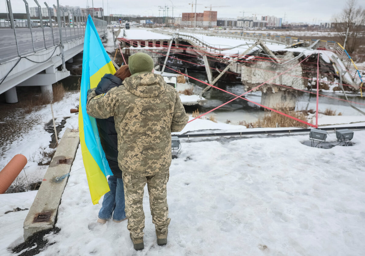 People attend a memorial event to mark the fourth anniversary of the full-scale Russian invasion, amid Russia's attack on Ukraine, at Romanivskyi Bridge, which was destroyed at the beginning of the war and which was the main way for evacuations of civilians from the front line area around the Ukrainian capital, in Irpin, outside of Kyiv, Ukraine February 24, 2026. REUTERS/Gleb Garanich TPX IMAGES OF THE DAY