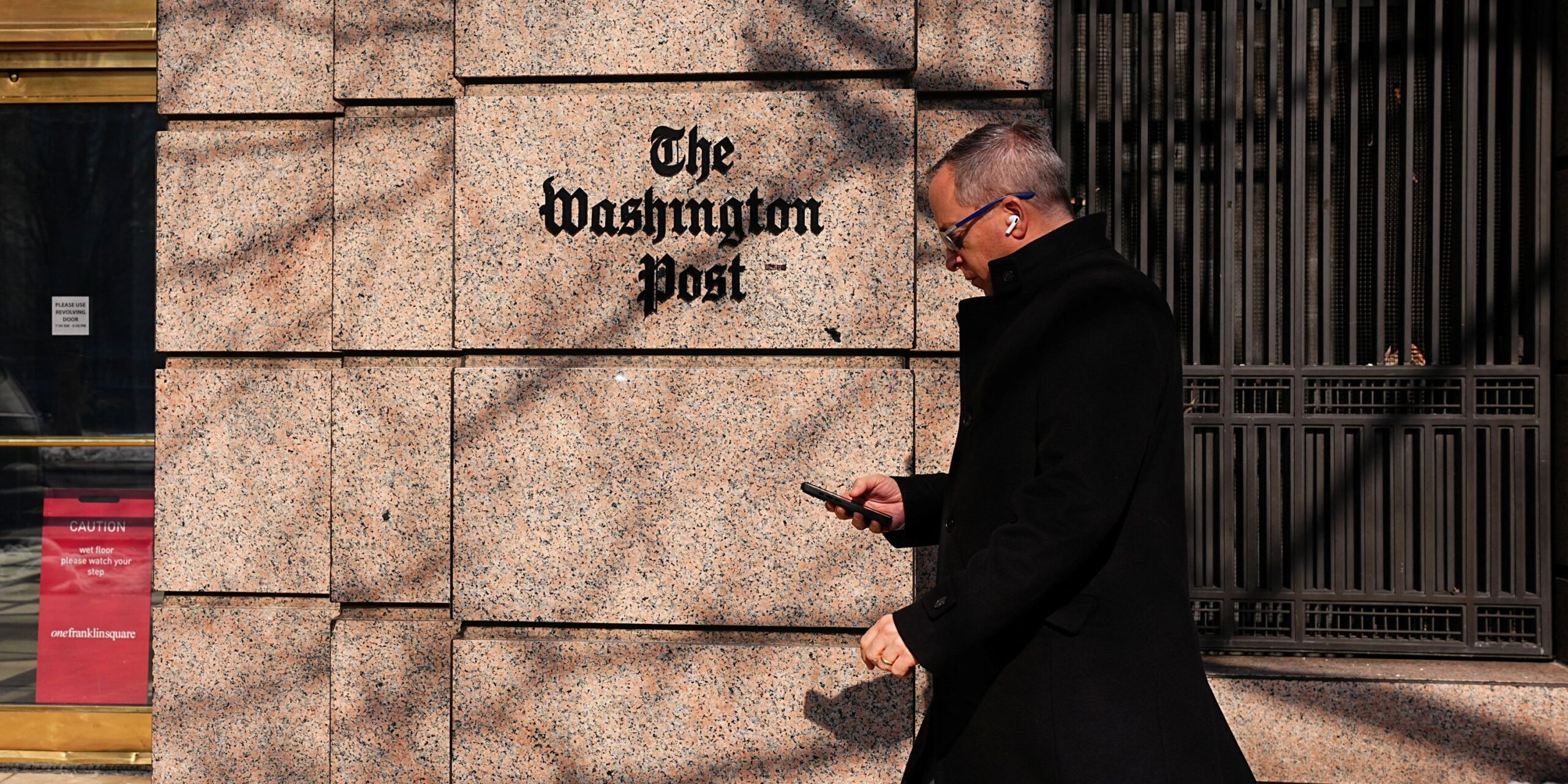 Ένας άνδρας περπατάει μπροστά από κεντρικά της Washington Post