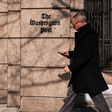 Ένας άνδρας περπατάει μπροστά από κεντρικά της Washington Post