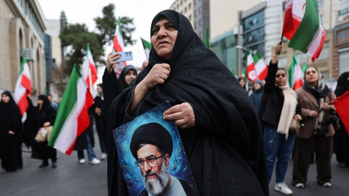 Γυναίκα κρατά φωτογραφία του Χαμενεΐ