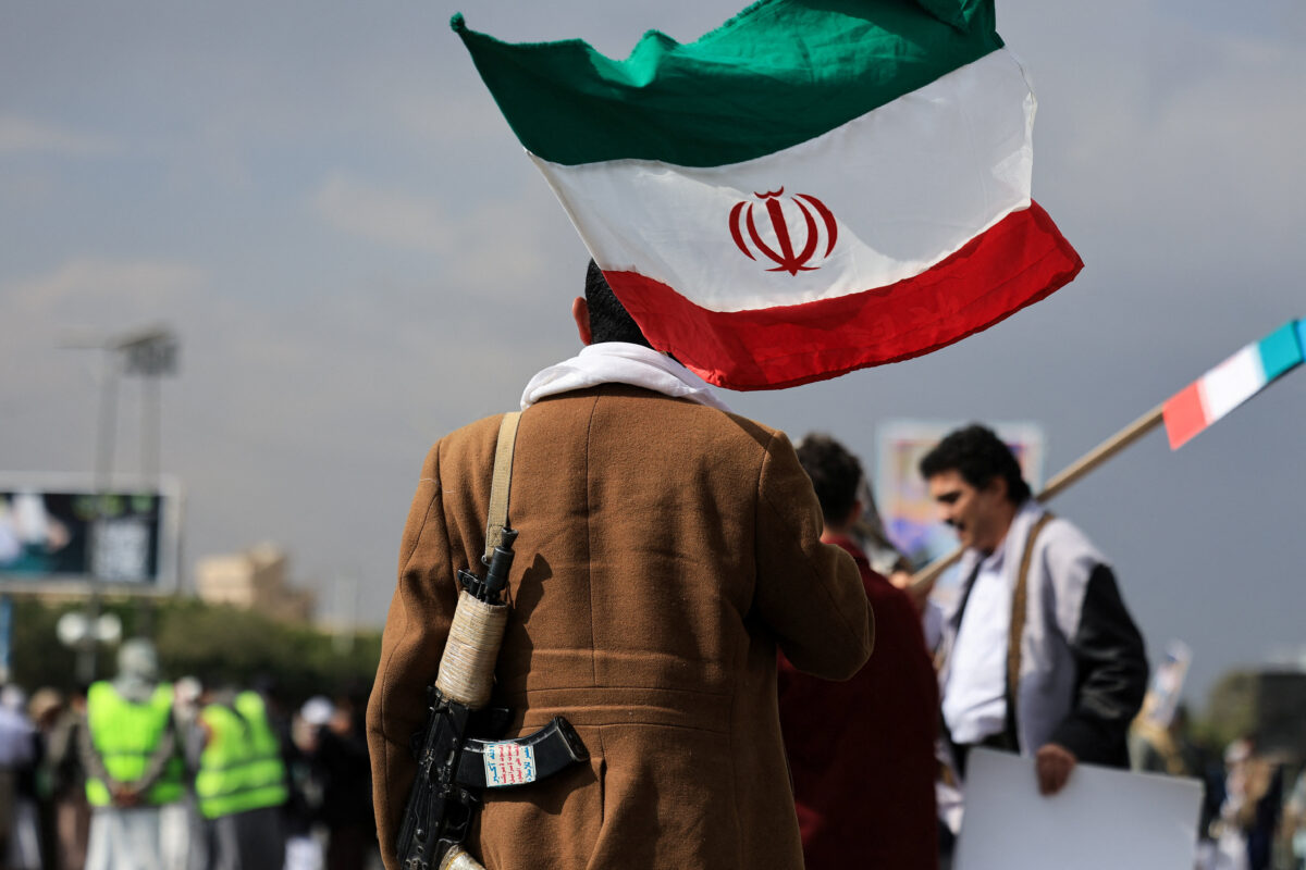 A person walks with an Iranian flag during a protest against Israel and the U.S. strikes on Iran, following the killing of Ali Khamenei, in Sanaa, Yemen, March 1, 2026. REUTERS/Khaled Abdullah