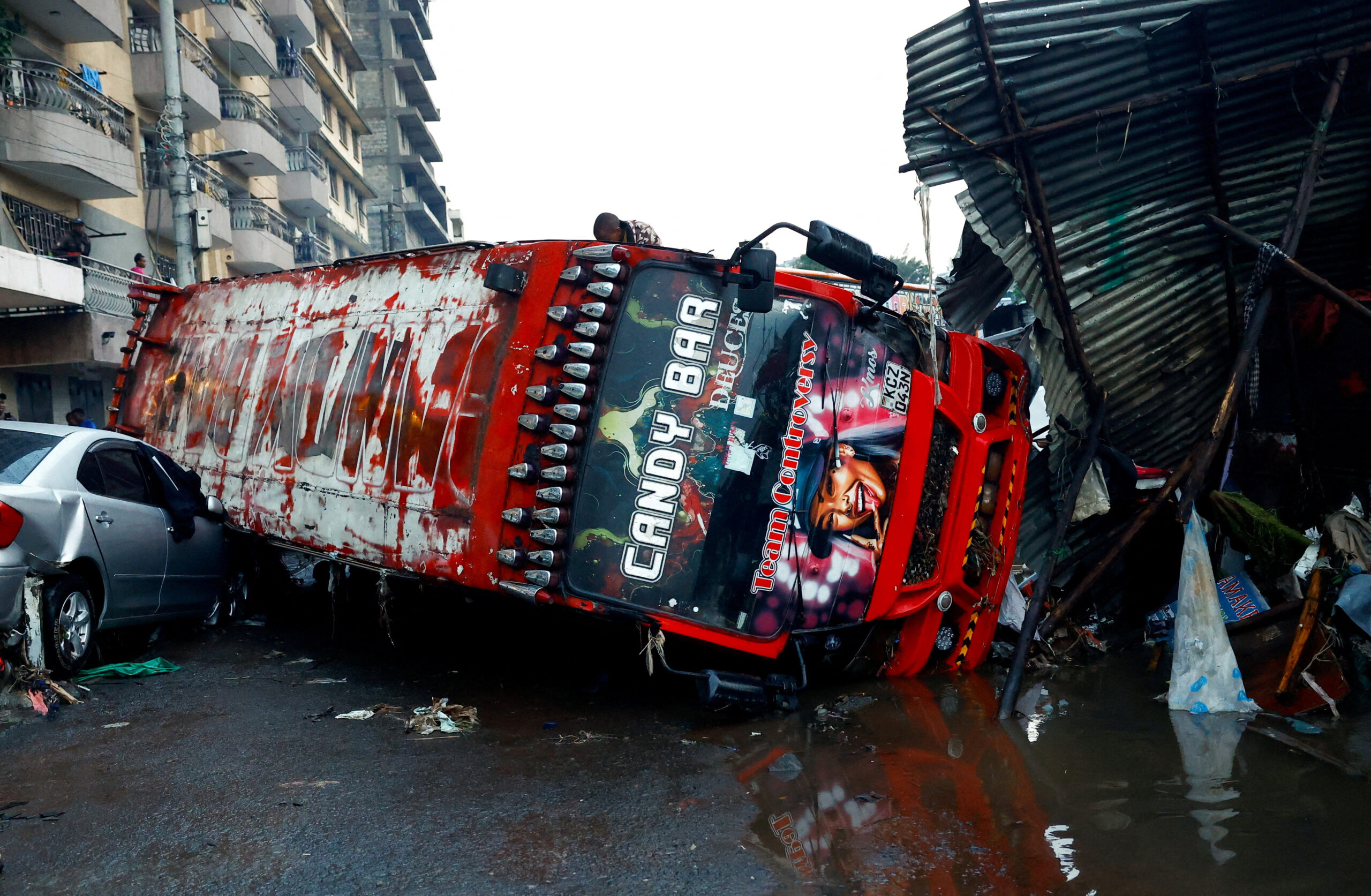 People move through debris at the site where people were killed as a result of heavy rainfall in the Grogan area, popular for automotive workshops and secondhand spare parts, in downtown Nairobi, Kenya, March 7, 2026. REUTERS/Monicah Mwangi