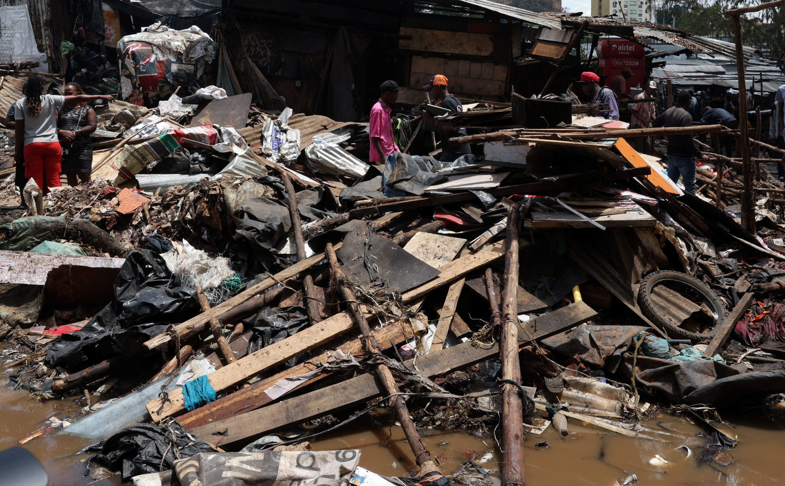 People move through debris at the site where people were killed as a result of heavy rainfall in the Grogan area, popular for automotive workshops and secondhand spare parts, in downtown Nairobi, Kenya, March 7, 2026. REUTERS/Monicah Mwangi