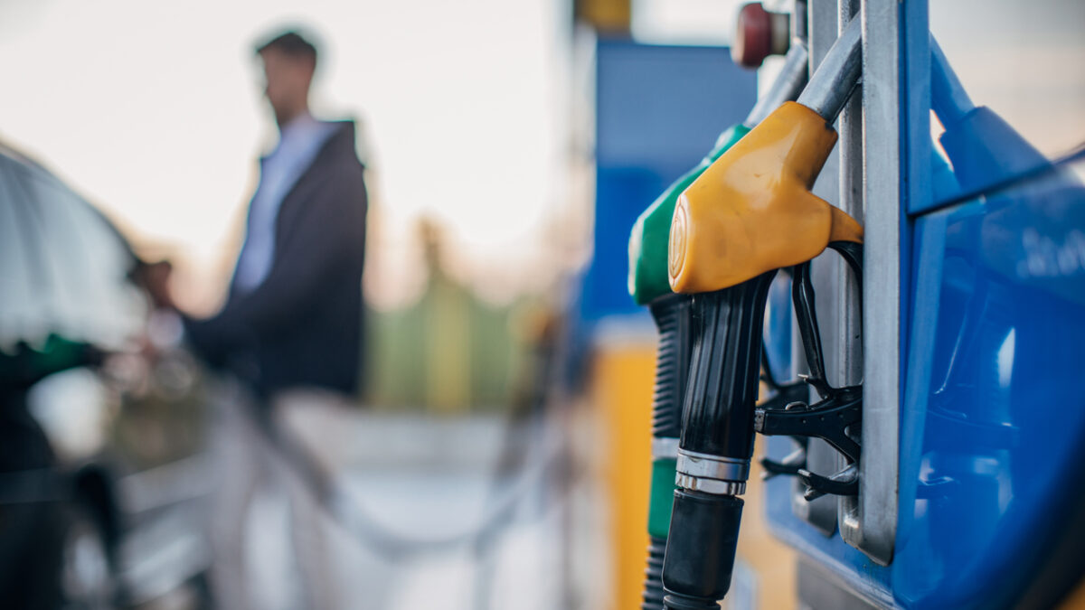 One man, pouring gasoline in his car at the gas station.