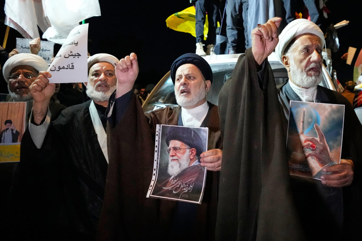Iraqi Shiite clerics hold a portrait of Iran's Supreme Leader Ayatollah Ali Khamenei during a protest against U.S. and Israeli attacks on multiple cities across Iran at a bridge leading to the fortified Green Zone where the U.S. embassy is located in Baghdad, Iraq, Saturday, Feb. 28, 2026. (AP Photo/Hadi Mizban)