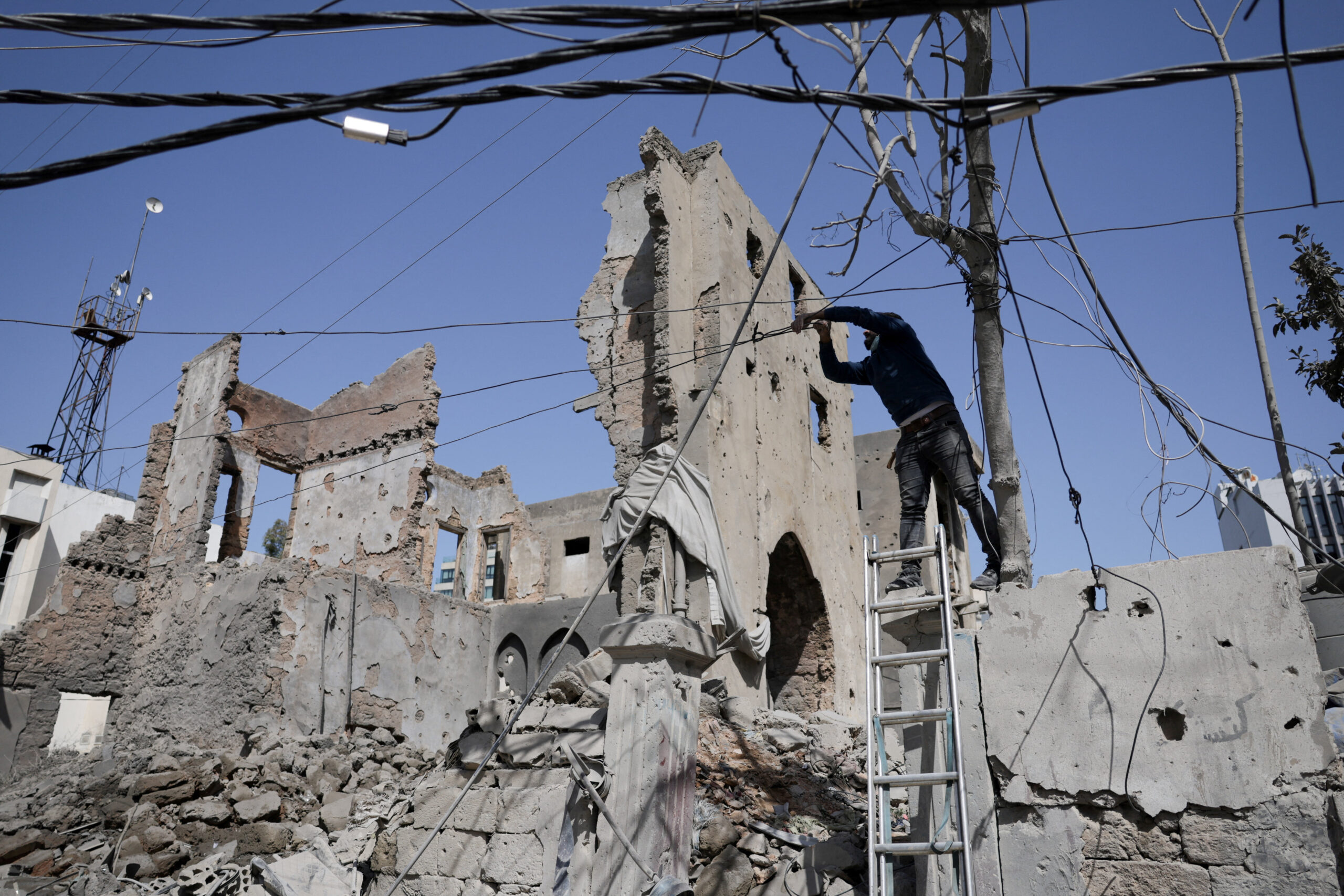 Aftermath of an Israeli strike, following an escalation between Hezbollah and Israel, in Beirut A man touches cables at the site of an Israeli strike, following an escalation between Hezbollah and Israel amid the U.S.-Israeli conflict with Iran, Zuqaq al-Blat district in central Beirut, Lebanon, March 18, 2026. REUTERS/Khalil Ashawi