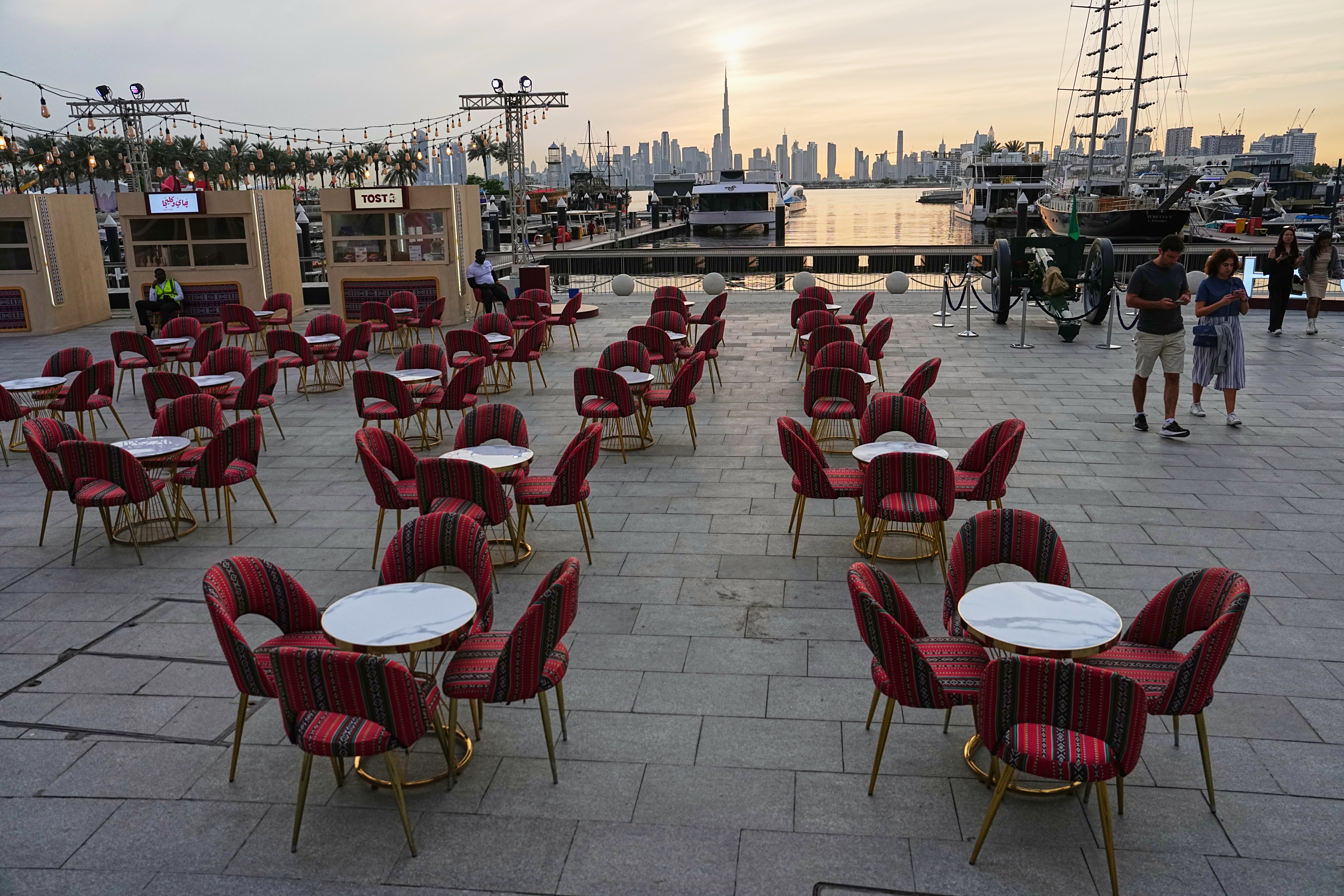 People walk past an outdoor empty restaurant at Dubai Creek Harbour in Dubai, United Arab Emirates, Wednesday, March 11, 2026. (AP Photo/Fatima Shbair)