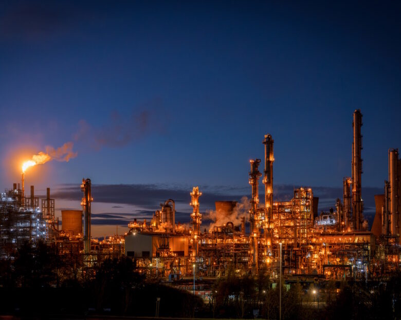 Smoke in the sky from a large flare stack at at Grangemouth petrochemical plant in central Scotland, photographed during the blue hour following sunset.