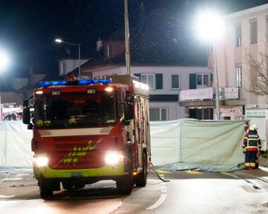 Πυροσβέστες και αστυνομικοί εγκαθιστούν φράγματα για να ασφαλίσουν την περιοχή όπου ένα ταχυδρομικό λεωφορείο πήρε φωτιά στο Kerzers της Ελβετίας.