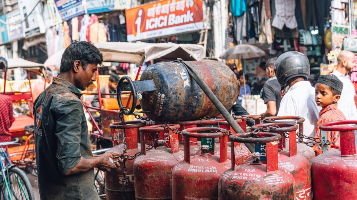 New Dehli, India - November 06, 2024: A bustling street in Chandni Chowk, Old Delhi, India, with a man beside a cart full of gas cylinders amidst local markets and passersby, highlighting daily life and urban dynamics.