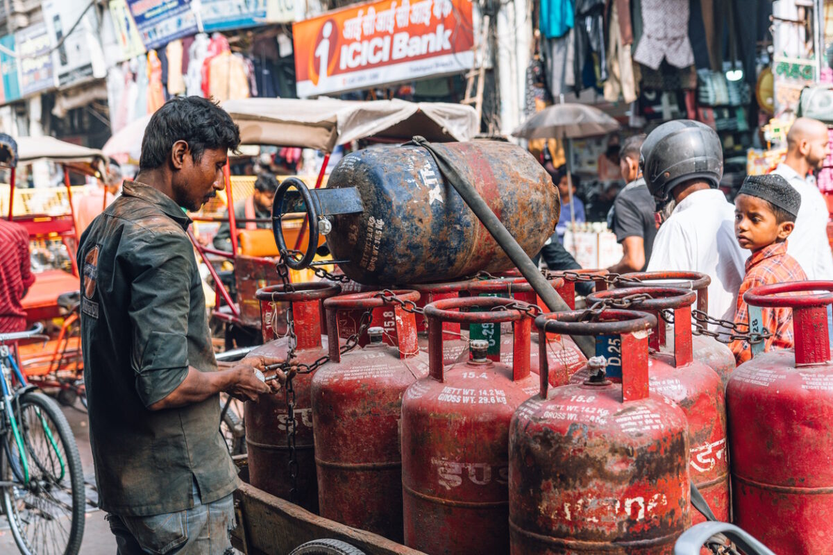 New Dehli, India - November 06, 2024: A bustling street in Chandni Chowk, Old Delhi, India, with a man beside a cart full of gas cylinders amidst local markets and passersby, highlighting daily life and urban dynamics.
