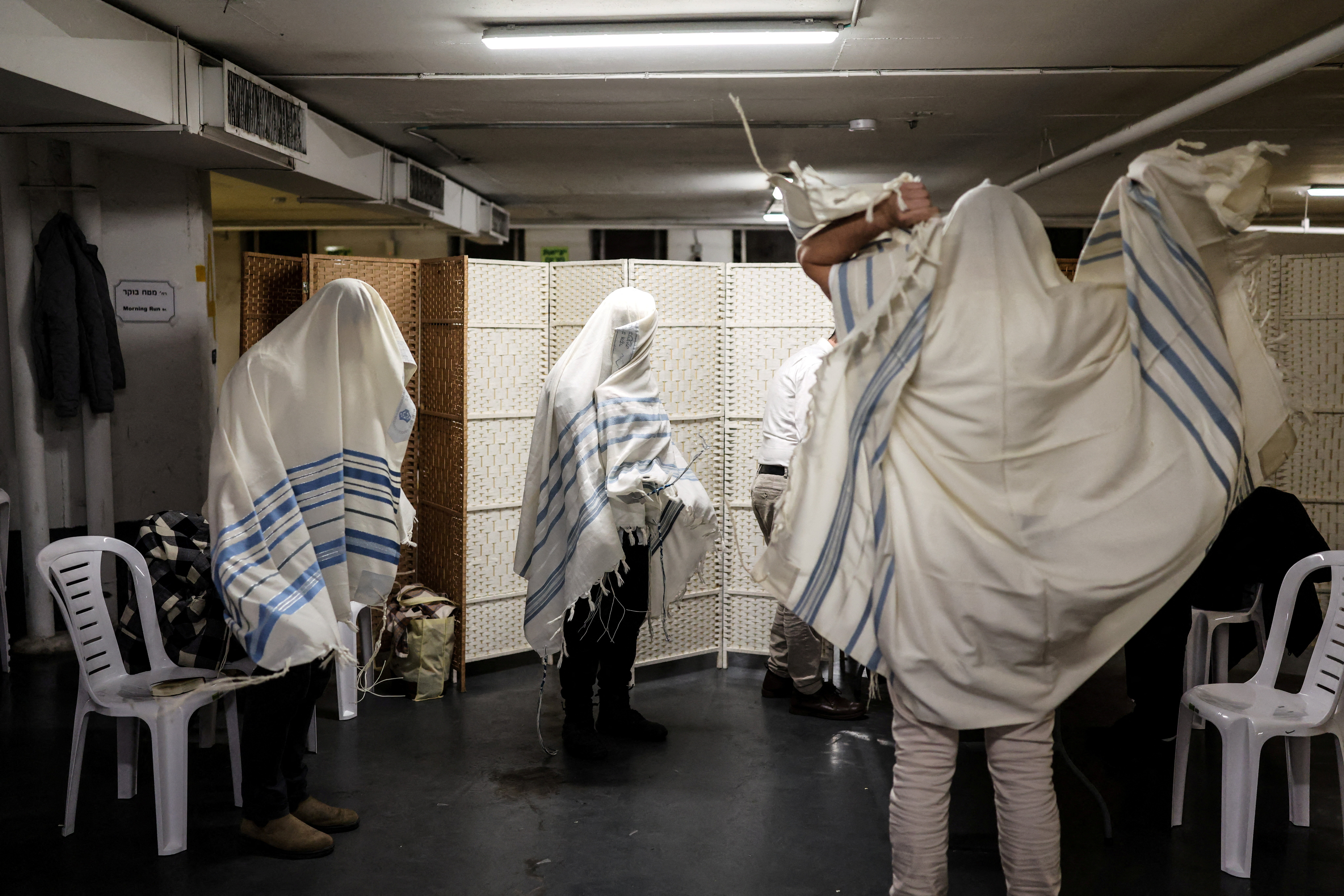 Israelis take part in morning prayers in an underground car park that functions as a bomb shelter, amid the U.S.-Israel conflict with Iran and during the Jewish holiday of Purim, in Tel Aviv, Israel March 3, 2026. REUTERS