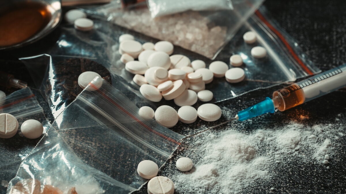 Hard drugs on dark table. Drug syringe and cooked heroin