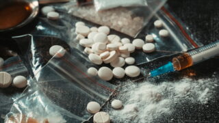 Hard drugs on dark table. Drug syringe and cooked heroin