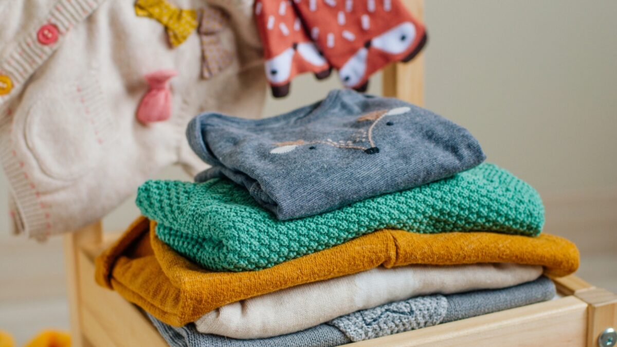 Baby organic clothes concept. Organic cotton clothing on the kids chair in children room. Selective focus.