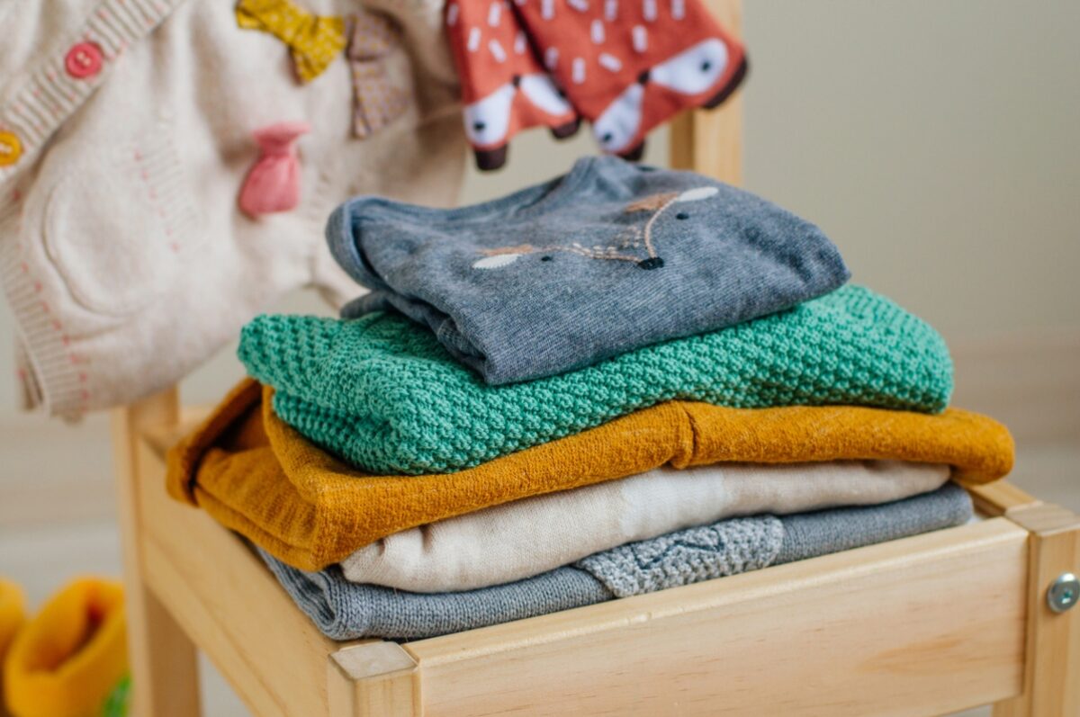 Baby organic clothes concept. Organic cotton clothing on the kids chair in children room. Selective focus.