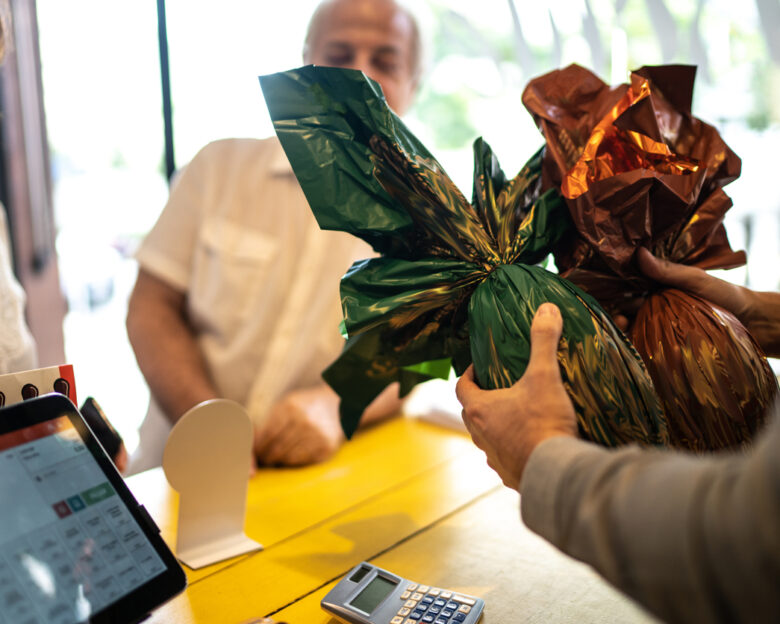 Owner selling easter egg for a senior couple in a store