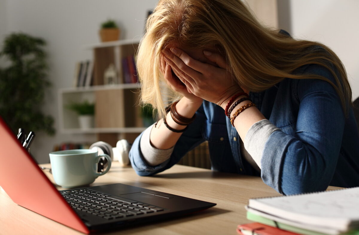 Close up of sad student receiving bad news on laptop sitting on a desk at home at night