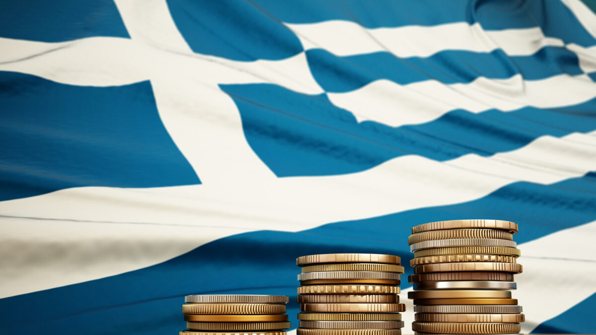 Rising stack of coins with Greek flag in the background. Economy, finance, interest rates concept.