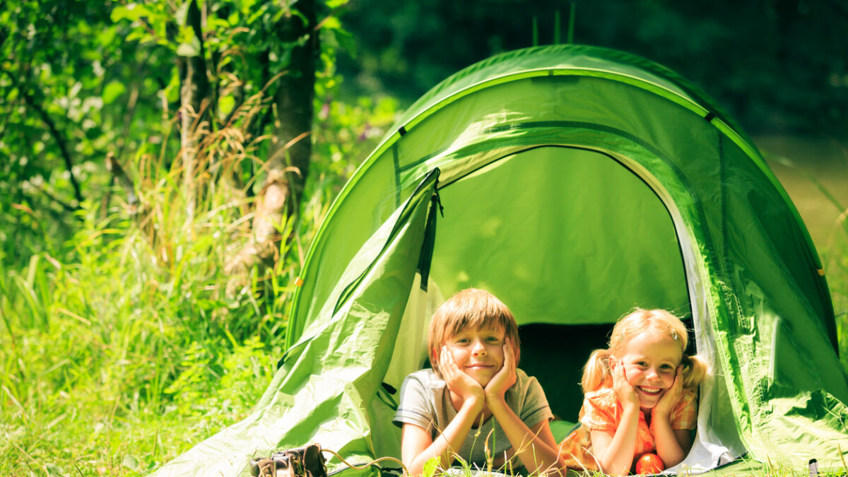 brother and sister are lying inside their tent