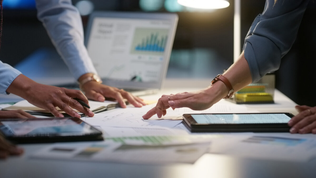 People, meeting and night graphs or laptop data analysis, for statistics research, budget report or teamwork. Business, group hands and documents, paperwork or computer screen for planning of charts