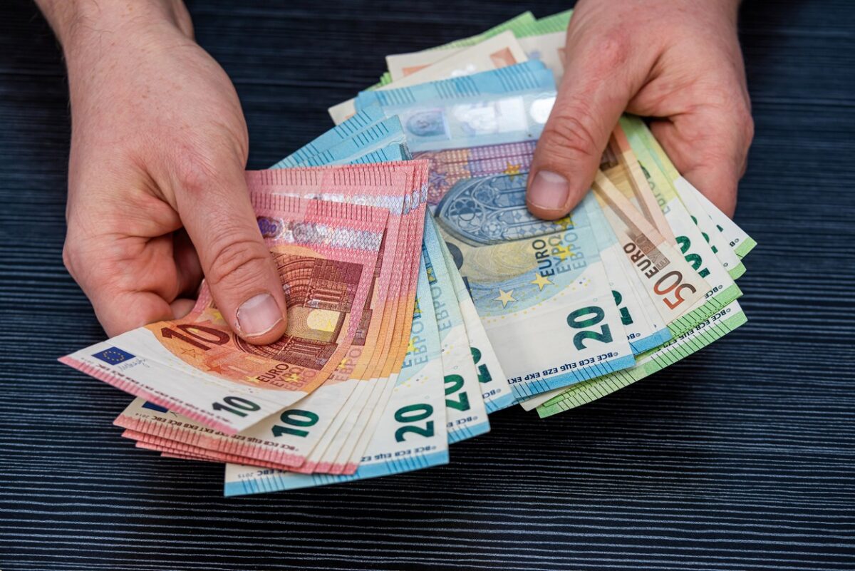 Man hold count euro money banknotes on black background. Financial concept