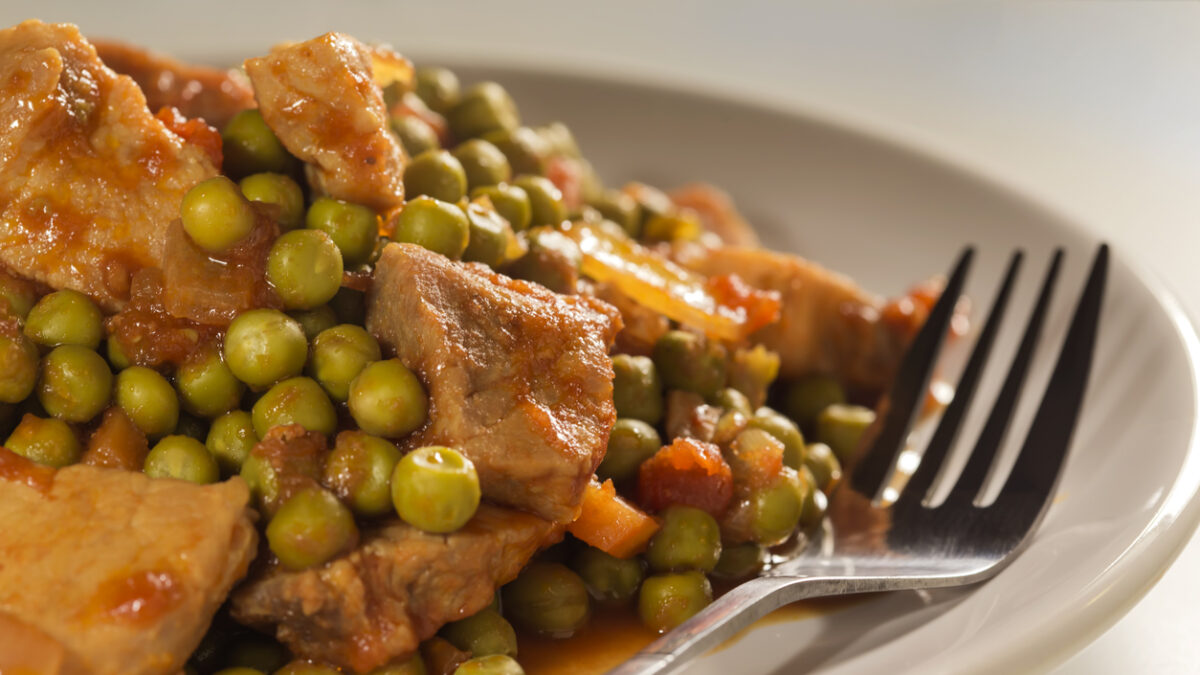 Stew with peas, pork meat, carrots, onions, tomato sauce and spices