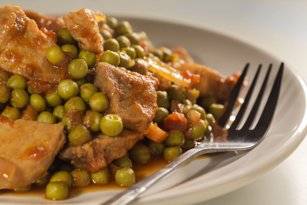Stew with peas, pork meat, carrots, onions, tomato sauce and spices