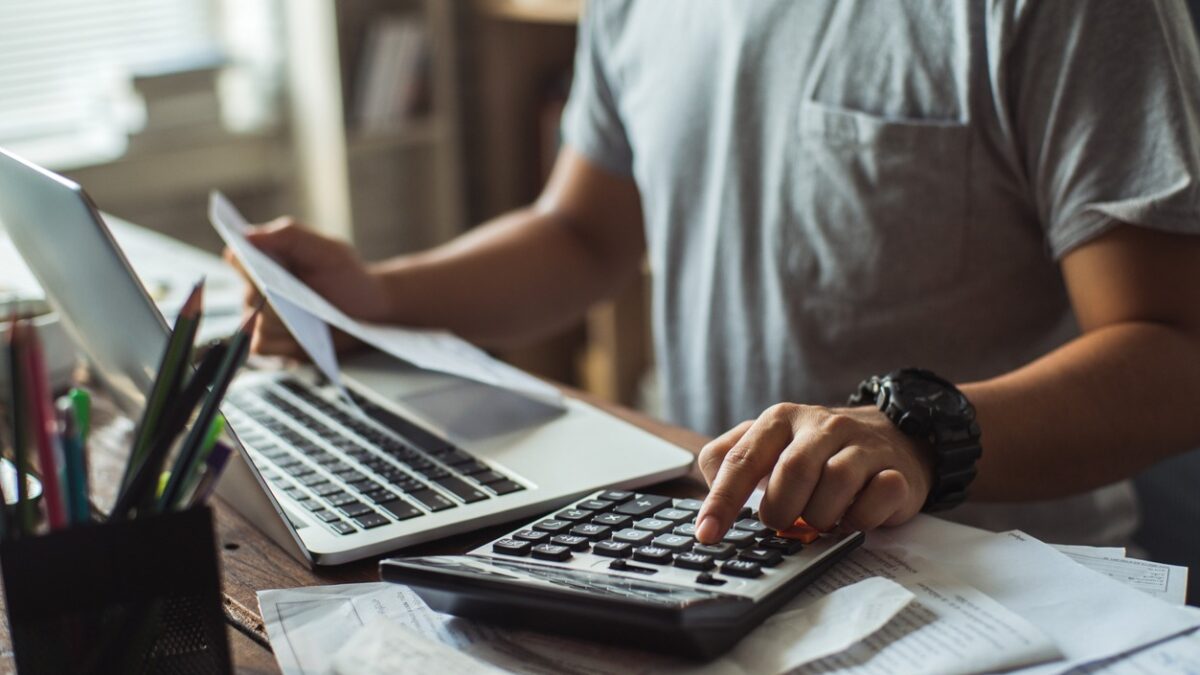 Men is calculating the cost of the bill. She is pressing the calculator