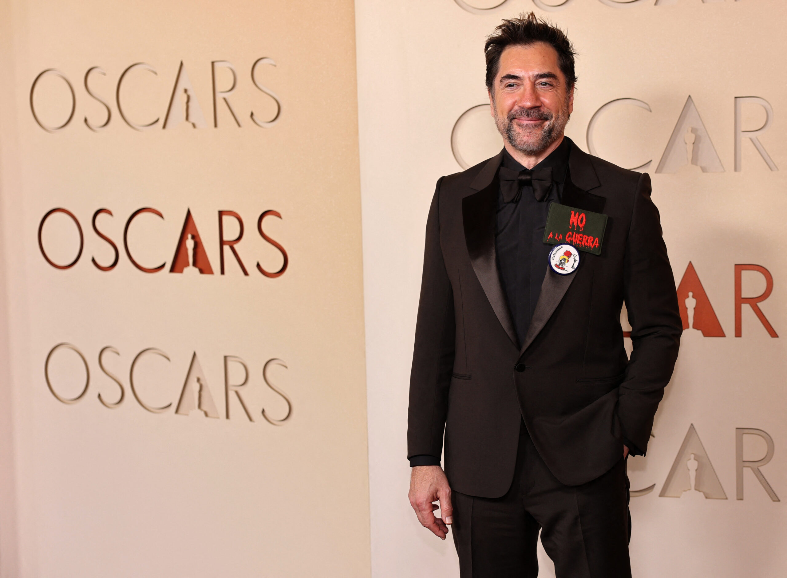 Javier Bardem wears a pin in support of Palestinians and a patch that reads "No to war" as he poses on the red carpet during the Oscars arrivals at the 98th Academy Awards in Hollywood, Los Angeles, California, U.S., March 15, 2026. REUTERS