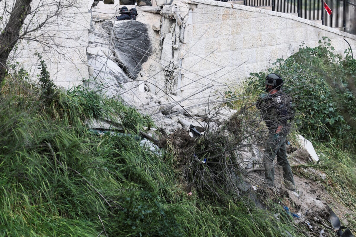 Μέλος των ιδραηλινών δυνάμεων ασφαλείας ελέγχει σημείο που χτυπήθηκε από θραύσματα ιρανικού πυραύλου στην Ιερουσαλήμ