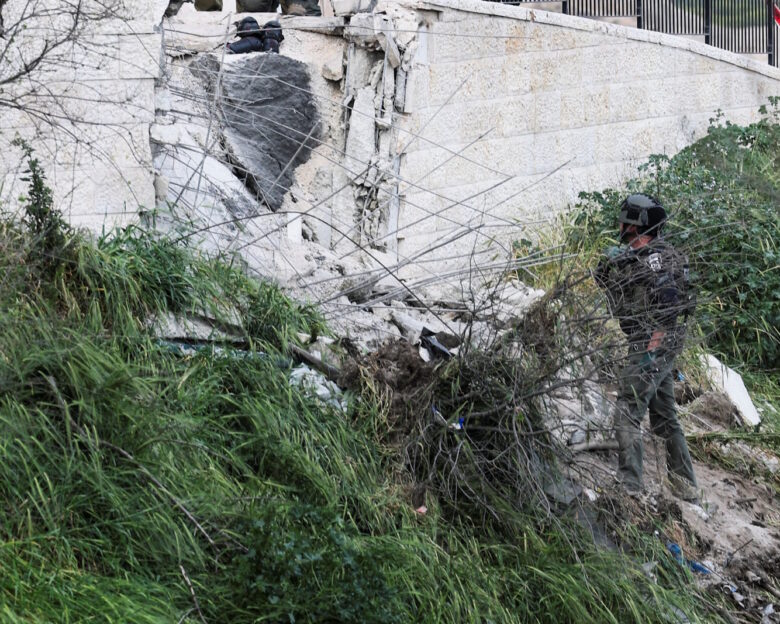 Μέλος των ιδραηλινών δυνάμεων ασφαλείας ελέγχει σημείο που χτυπήθηκε από θραύσματα ιρανικού πυραύλου στην Ιερουσαλήμ