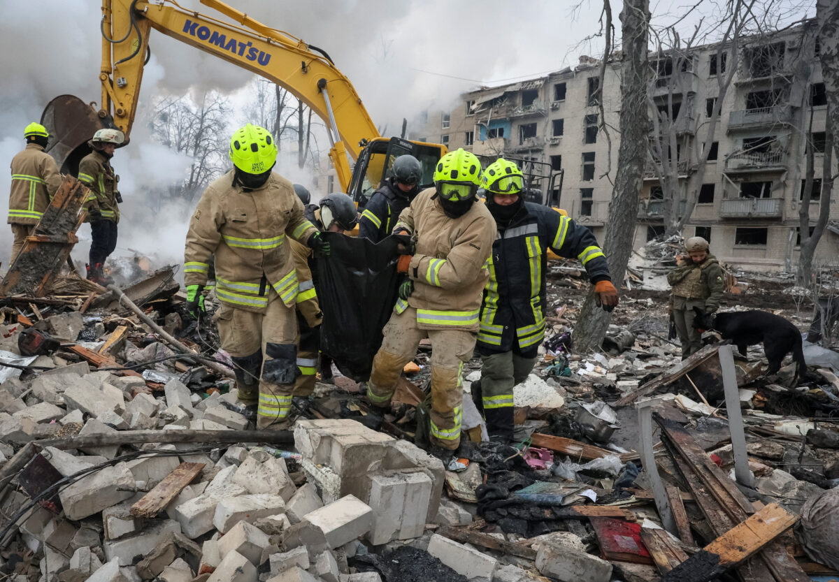 Rescuers carry a bag with the body of a person found under debris of an apartment building which was hit during overnight Russian missile strikes, amid Russia's attack on Ukraine, in Kharkiv, Ukraine March 7, 2026. REUTERS/Vyacheslav Madiyevskyy