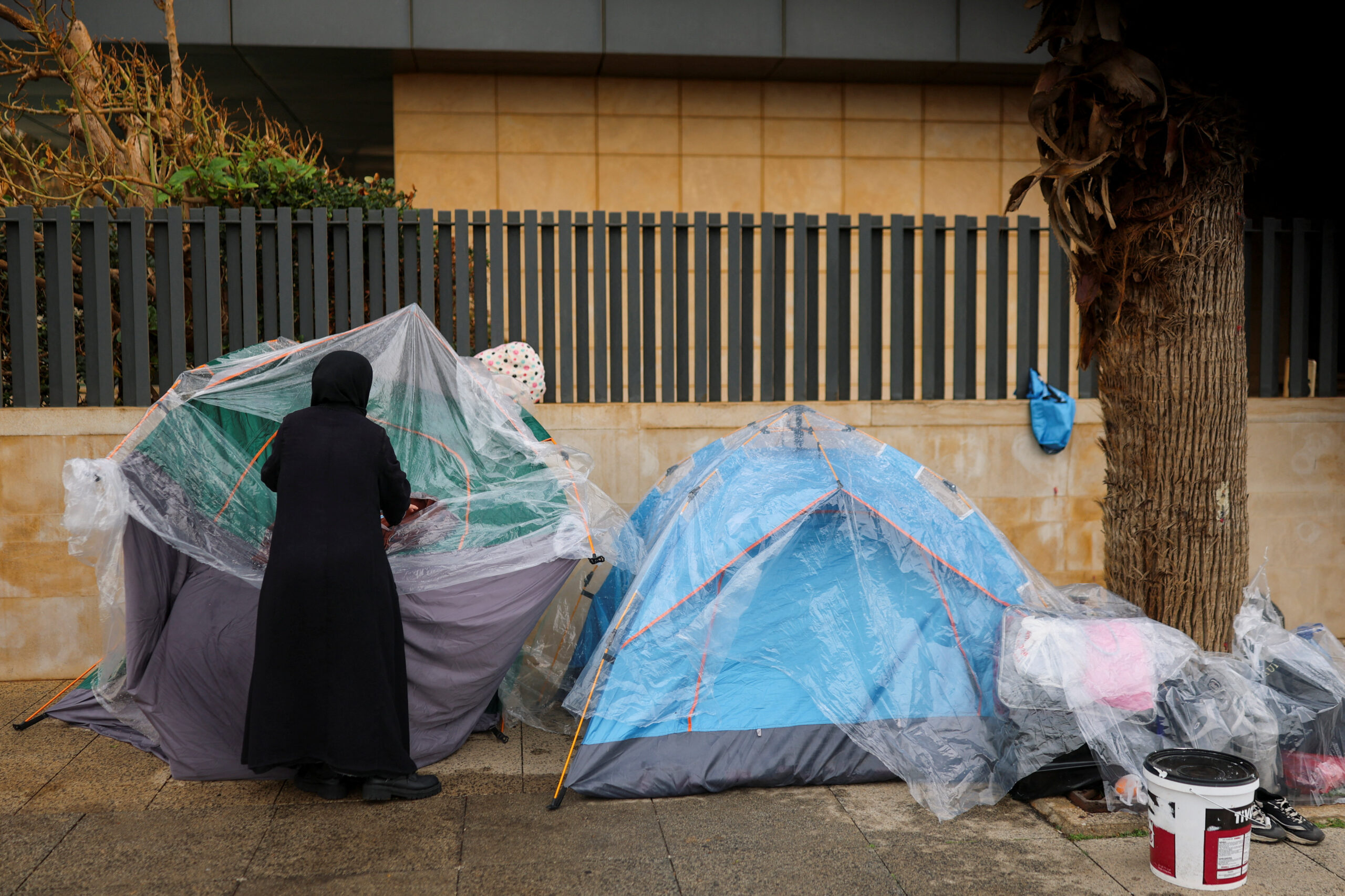 A woman covers a tent from the rain, amid the U.S.-Israeli conflict with Iran A woman covers a tent from the rain, at a corniche overlooking the sea, following an escalation between Hezbollah and Israel amid the U.S.-Israeli conflict with Iran, in Beirut, Lebanon, March 14, 2026. REUTERS/Claudia Greco