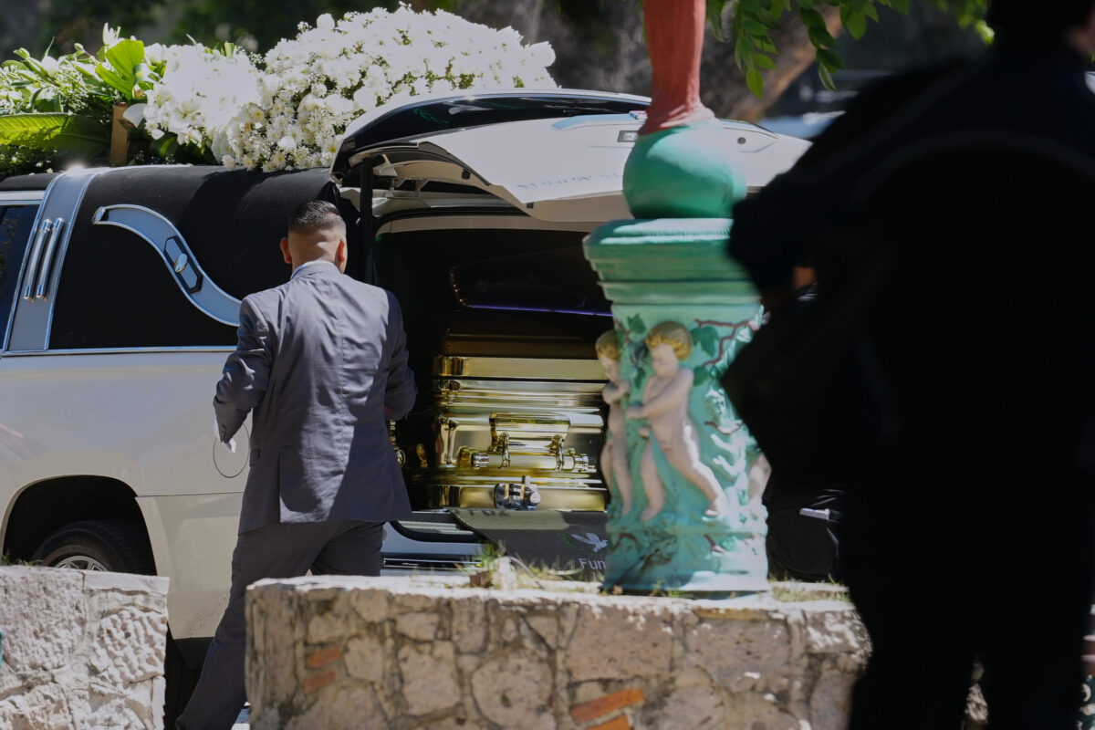 A funeral worker opens the door of a car carrying the remains of who authorities identified as the late Jalisco New Generation Cartel leader Nemesio Oseguera, alias "El Mencho," at Recinto de Paz cemetery in Guadalajara, Mexico, Monday, March 2, 2026. (AP Photo/Refugio Ruiz)