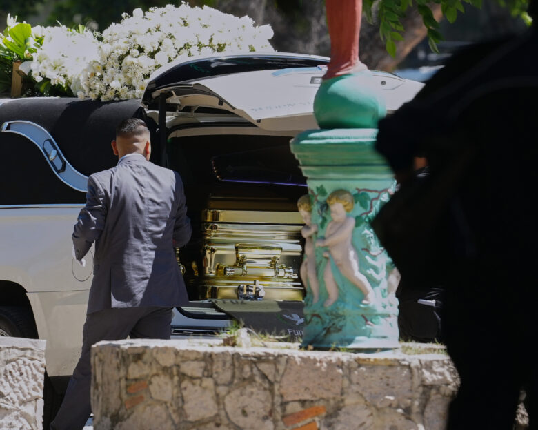 A funeral worker opens the door of a car carrying the remains of who authorities identified as the late Jalisco New Generation Cartel leader Nemesio Oseguera, alias "El Mencho," at Recinto de Paz cemetery in Guadalajara, Mexico, Monday, March 2, 2026. (AP Photo/Refugio Ruiz)