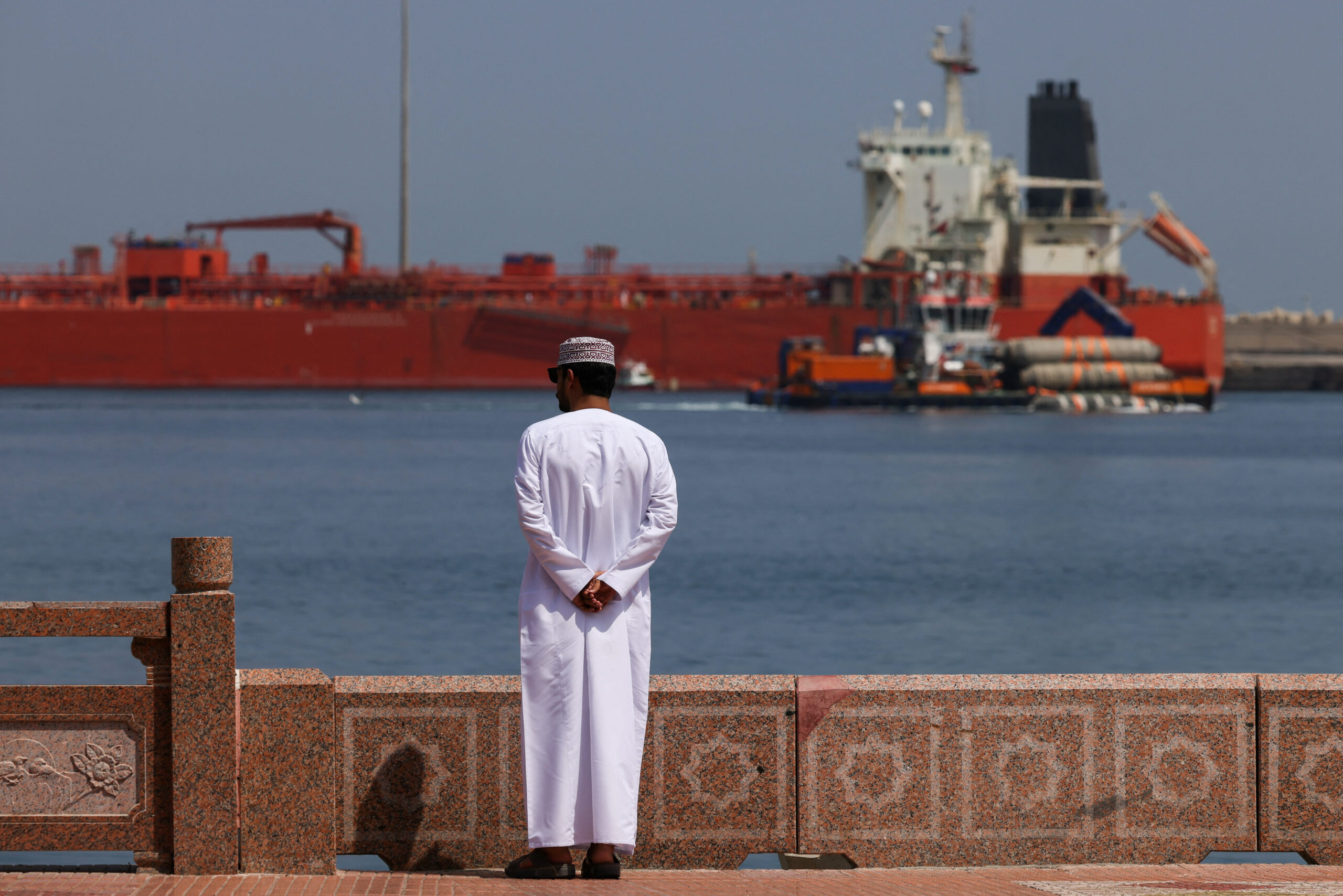 Man near waterfront as vessel at anchor at Sultan Qaboos Port in Muscat A man stands near the waterfront as a vessel sits at anchor, amid the U.S.-Israeli conflict with Iran, at Sultan Qaboos Port in Muscat, Oman, March 16, 2026. REUTERS/Stelios Misinas