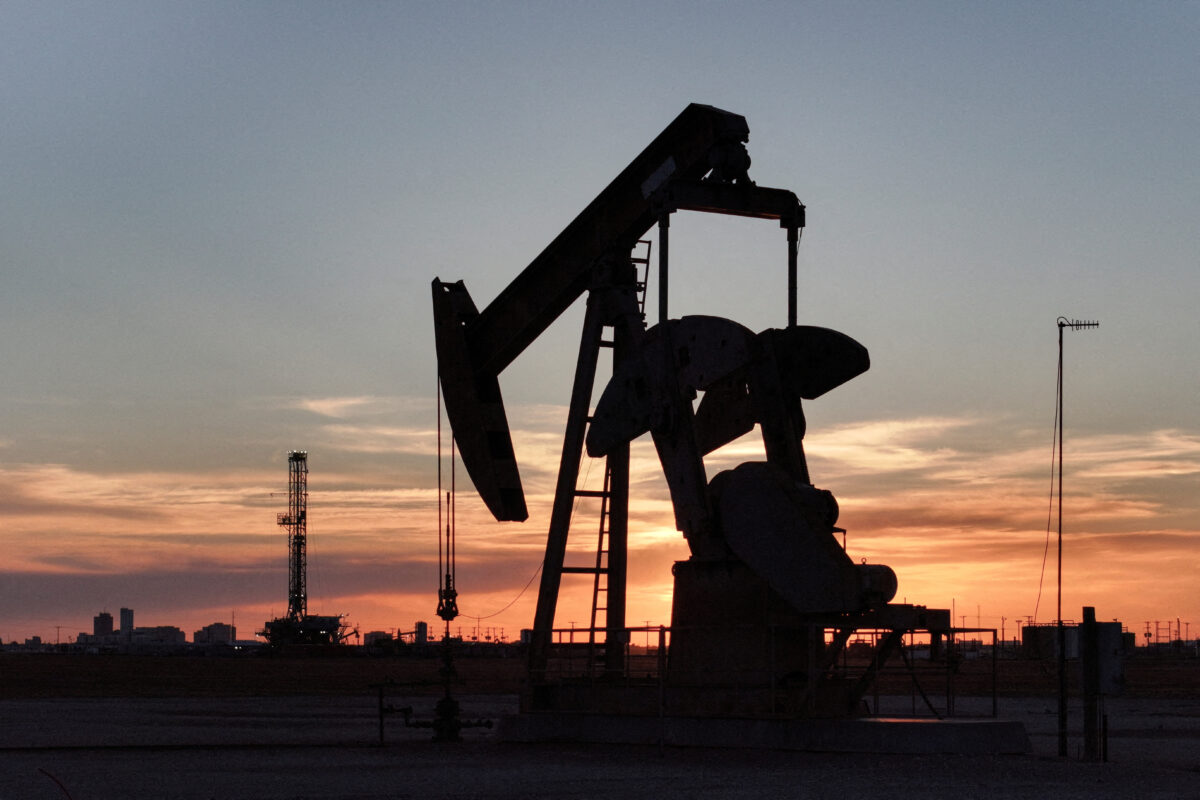 FILE PHOTO: A drone view of a pump jack and drilling rig south of Midland, Texas, U.S. June 11, 2025. REUTERS/Eli Hartman//File Photo
