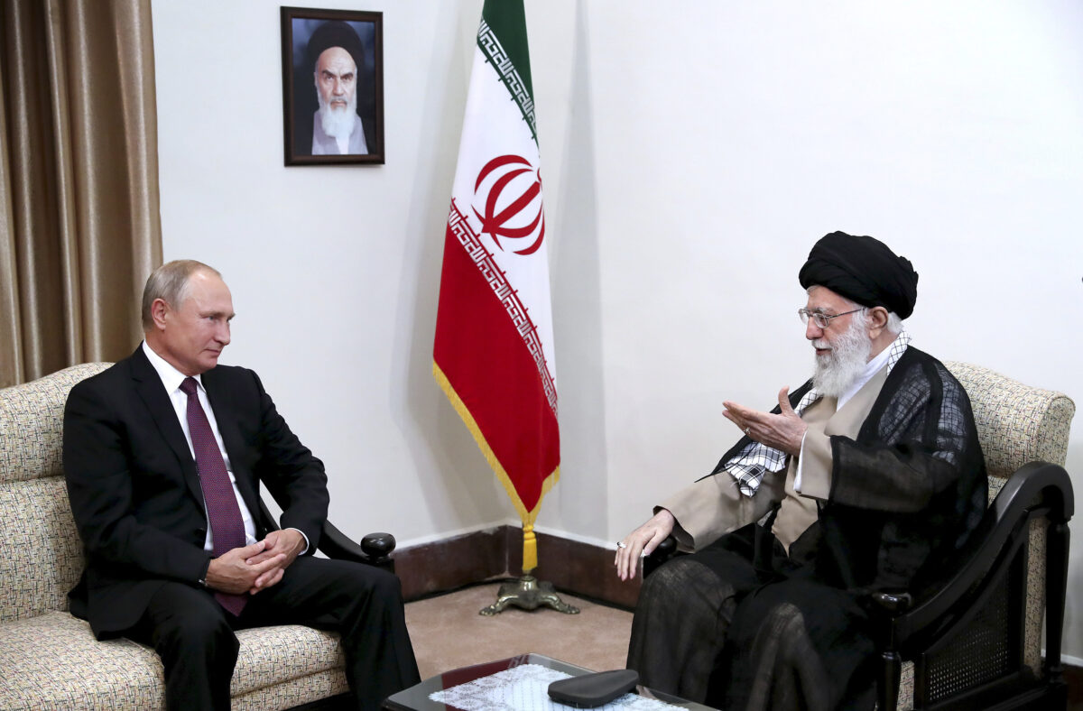 In this picture released by an official website of the office of the Iranian supreme leader, Supreme Leader Ayatollah Ali Khamenei, right, speaks with Russia's President Vladimir Putin, in Tehran, Iran, Friday, Sept. 7, 2018. A portrait of the late Iranian revolutionary founder Ayatollah Khomeini hangs on the wall. (Office of the Iranian Supreme Leader via AP)