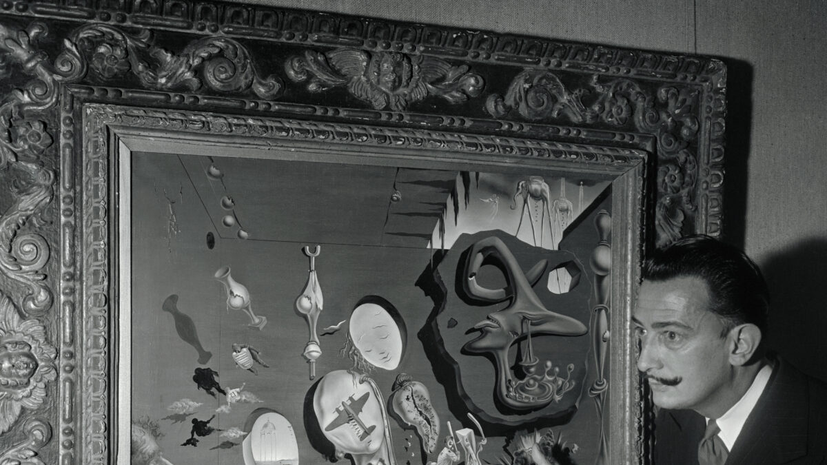 (Original Caption) Salvador Dali (right) points to figures on his new canvas, called Uranium and Atomica Melancholia Idyll, currently on display at the Bignou Gallery, 32 East 57th Street. Atoms burst all over the canvas which contains, among other things, sliding baseball players, an umpire, a catcher, and the artist's characteristic melted clocks.