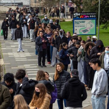 Το προσωπικό και οι φοιτητές, μερικοί με μάσκες, περιμένουν στην ουρά για να παραλάβουν αντιβιοτικά στο Πανεπιστήμιο του Κεντ λόγω της επιδημίας μανηγγίτιδας