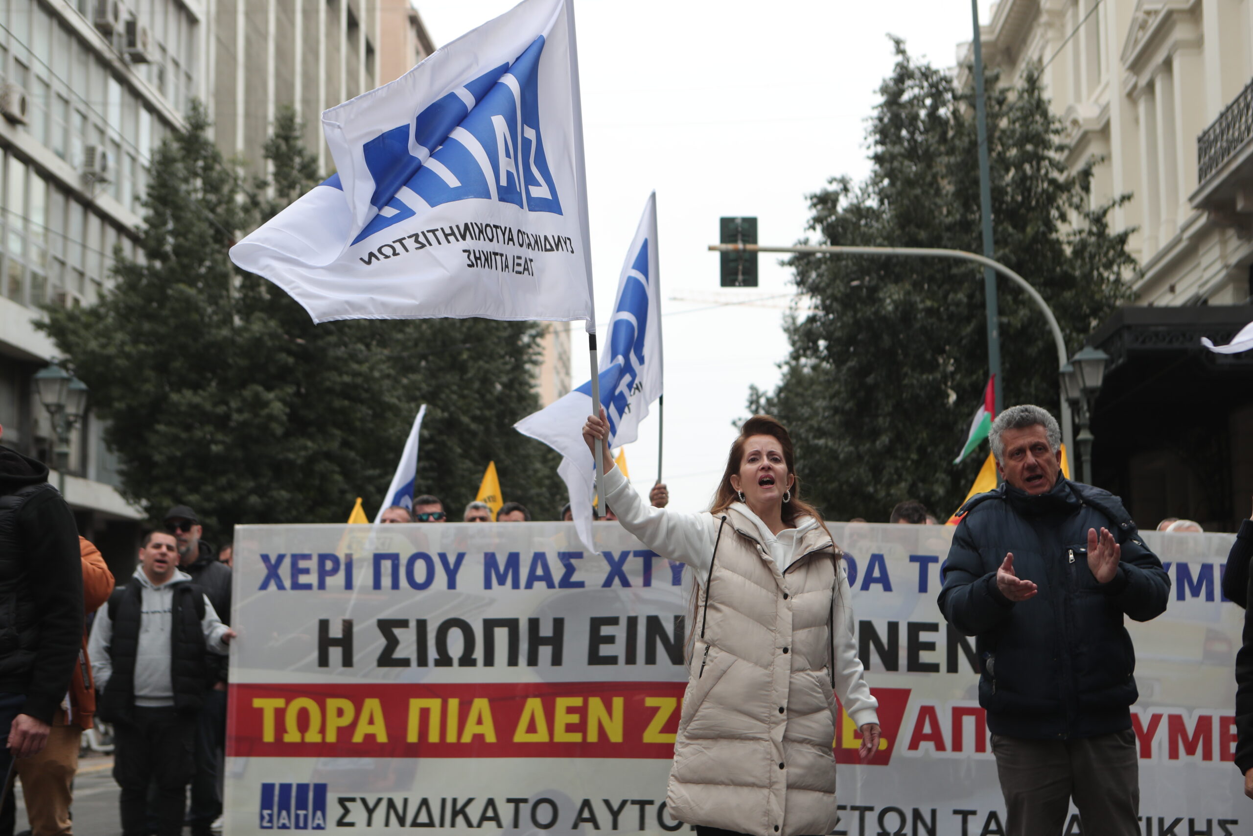 Απεργιακή συγκέντρωση αυτοκινητιστών ταξί της Αττικής, στα γραφεία του ΣΑΤΑ και πορεία στην πλατεία Συντάγματος, Τρίτη 17 Μαρτίου 2026. Οι επαγγελματίες αυτοκινητιστές αντιδρούν σε διατάξεις του νομοσχεδίου για την ηλεκτροκίνηση και ξεκίνησαν εικοσιτετράωρες, επαναλαμβανόμενες απεργιακές κινητοποιήσεις. Ανάμεσα στα αιτήματά τους είναι η παράταση του μέτρου για την ηλεκτροκίνηση που προωθεί το αρμόδιο υπουργείο μέχρι το 2035, καθότι υποστηρίζουν πως είναι πολύ ακριβά τα οχήματα και δεν υπάρχουν και οι υποδομές ώστε να καλυφθούν οι ανάγκες αυτών των οχημάτων. Στο επίκεντρο της αντιπαράθεσης με την κυβέρνηση είναι και το άρθρο 52 που αφορά τα επιβατικά ιδιωτικής χρήσης με οδηγό. Οι εκπρόσωποι των ταξί υποστηρίζουν πως αυτή η ρύθμιση, ανοίγει το δρόμο σε εταιρείες ενοικιαζομένων με οδηγό, δημιουργώντας, όπως λένε, συνθήκες αθέμιτου ανταγωνισμού καθώς θα πραγματοποιούν αστικές κούρσες.   (ΣΩΤΗΡΗΣ ΔΗΜHΤΡΟΠΟΥΛΟΣ