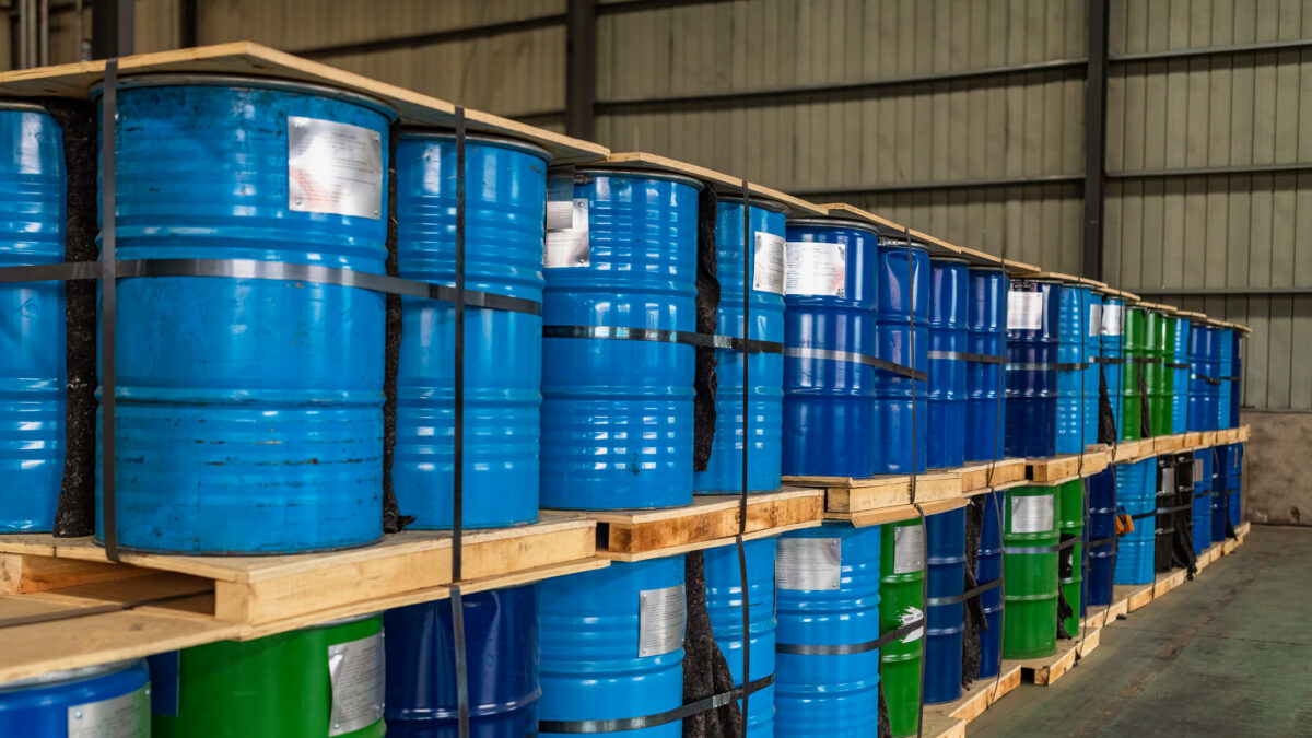 Blue Metal Oil Barrels Stacked In A Warehouse