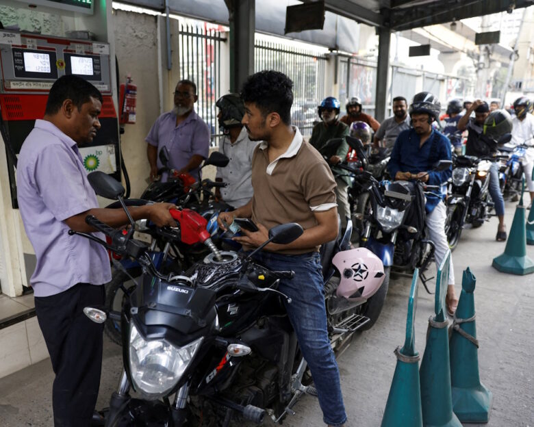FILE PHOTO: A man refuels his motorcycle at a fuel station, as concerns grow over fuel supplies following U.S.-Israel conflict with Iran, in Dhaka, Bangladesh, March 6, 2026.