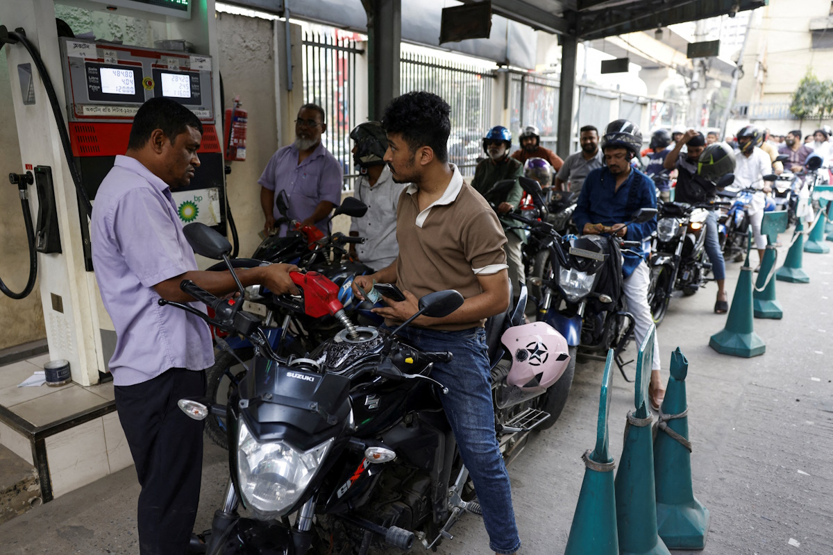 FILE PHOTO: A man refuels his motorcycle at a fuel station, as concerns grow over fuel supplies following U.S.-Israel conflict with Iran, in Dhaka, Bangladesh, March 6, 2026.