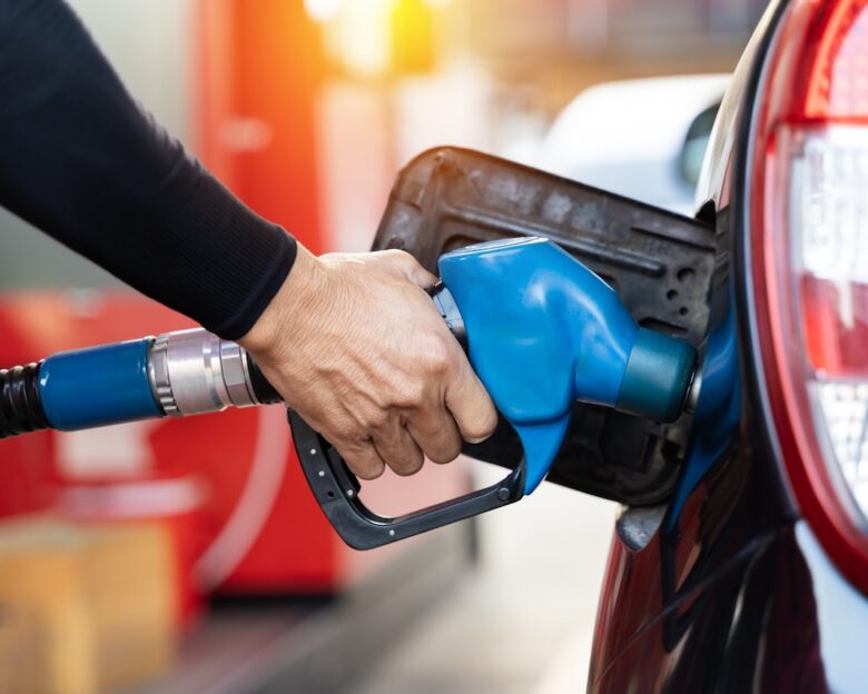 Refueling the car at a gas station fuel pump. Man driver hand refilling and pumping gasoline oil the car with fuel at he refuel station. Car refueling on petrol station. Fuel pump at station