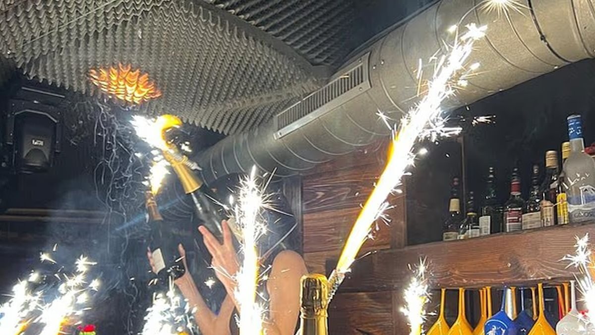 Η σερβιτόρα με το κράνος που κρατούσε τις σαμπάνιες με τα κεριά-βεγγαλικά στο μπαρ