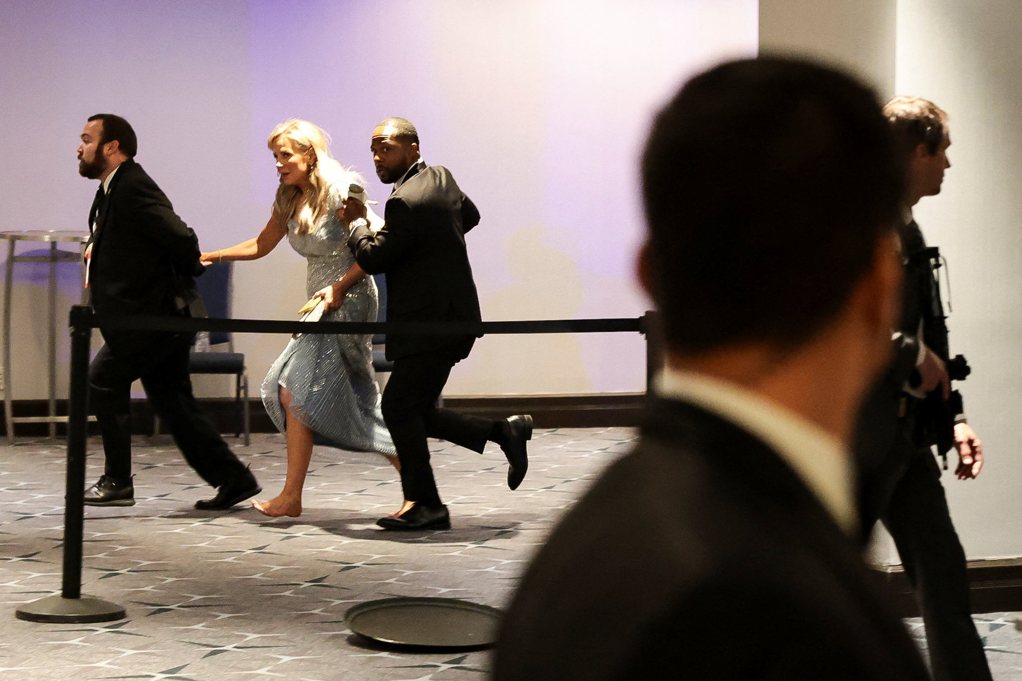 Security officials evacuate a guest as a shooter opens fire during the annual White House Correspondents' Association dinner in Washington, D.C., U.S., April 25, 2026. REUTERS