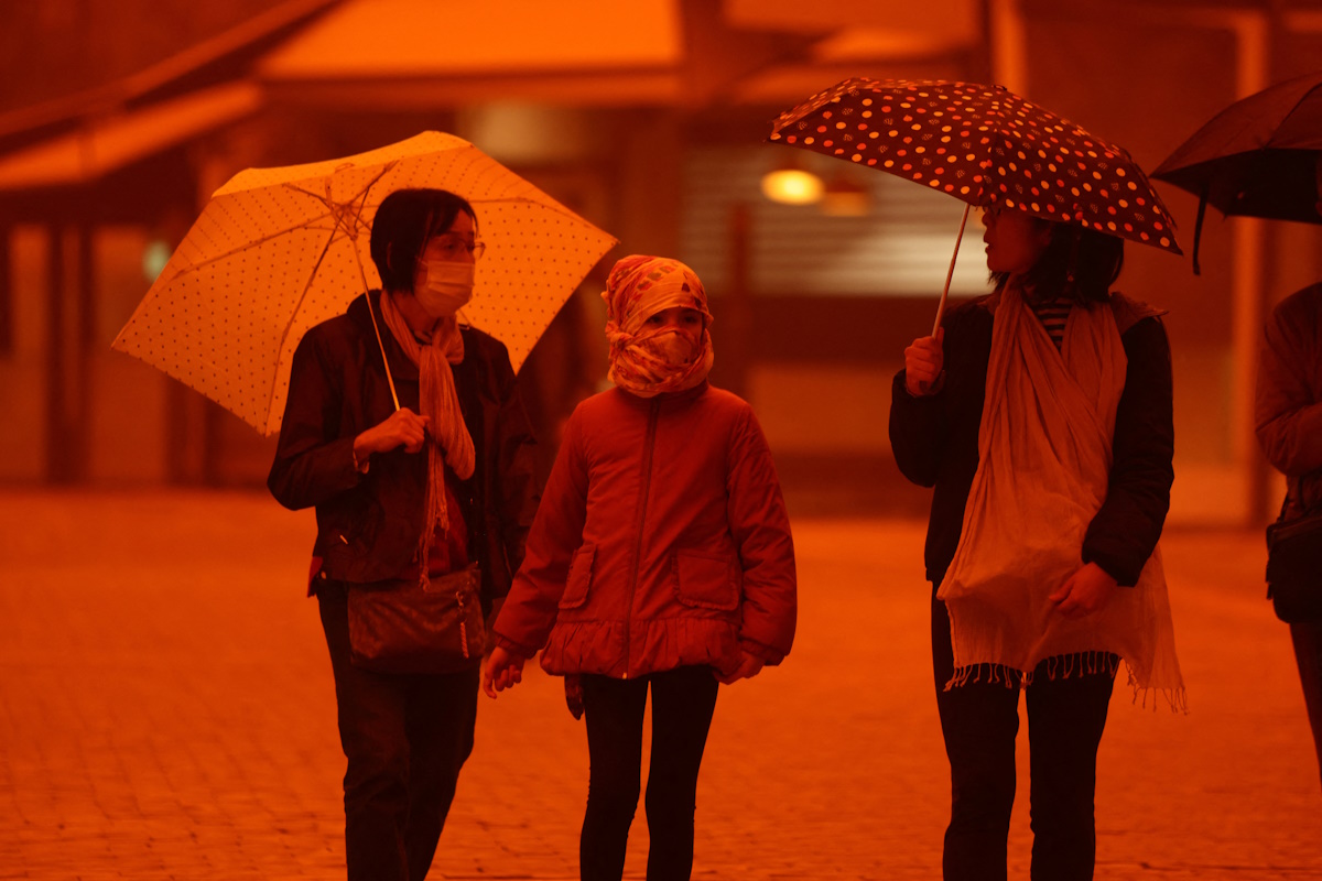 People walk amid a haze caused by sand dust from the Sahara, due to strong southern winds, in Heraklion, Crete island, April 1, 2026. REUTERS